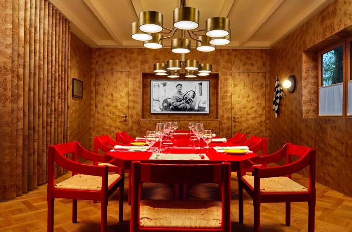 A private dining arrangement featuring a red table and chairs, located at the Ferrari Museum in Maranello, Italy, one of Airbnb's new Icon listings.