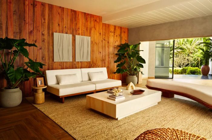 A stylish living area in Bollywood actress Janhvi Kapoor's bright and airy home in Chennai, India, featuring wooden walls and floors along with white furnishings.