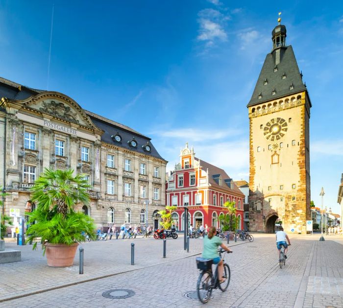 A cyclist makes their way toward the Old City Gate in the heart of Speyer, Germany