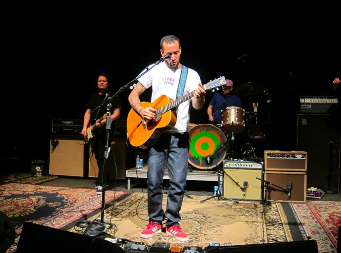 Ben Harper strums his acoustic guitar on stage at the 9:30 Club.