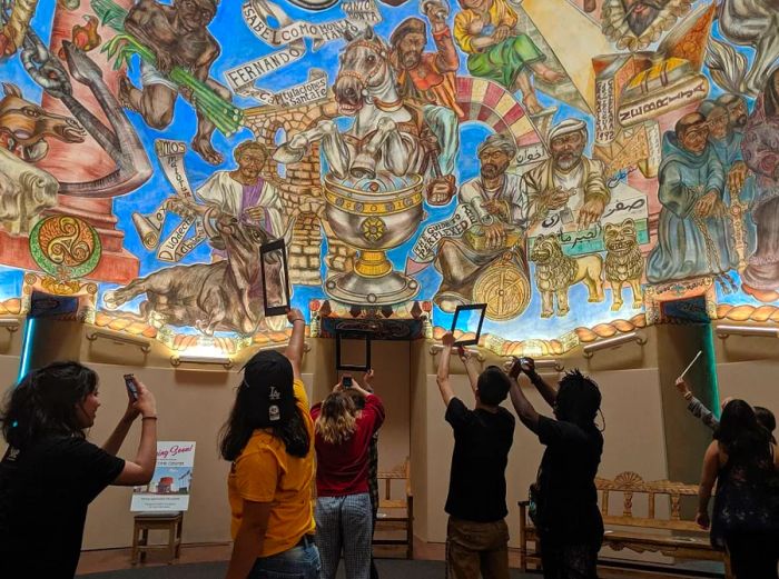 Visitors capturing memories of a beautifully painted ceiling at the National Hispanic Cultural Center