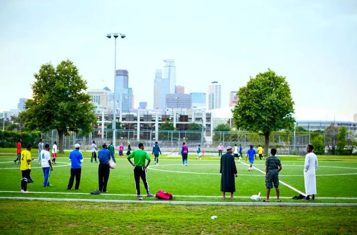 Individuals enjoying a game of soccer at Cedar Riverside Park.