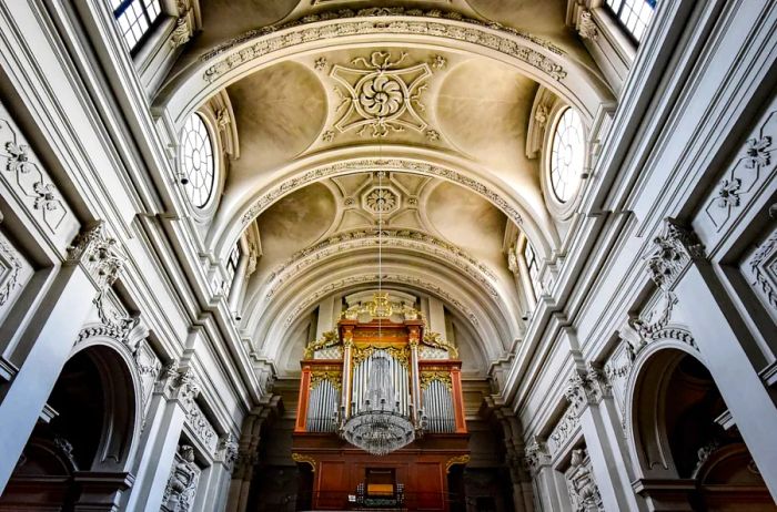 The intricately designed white ceiling of the Eglise Saint-Croix Church in Carouge