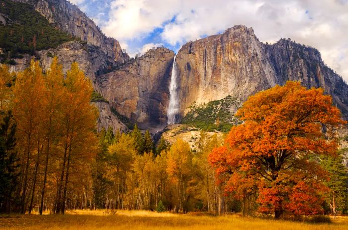 Yosemite Valley showcasing its waterfall alongside vibrant autumn trees.