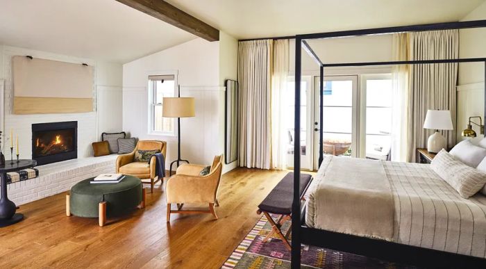 Inside a white two-bedroom suite at the Inn at Mattei's Tavern, featuring a cozy fireplace and elegant hardwood floors.