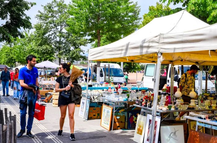 Antiques showcased beneath tents and on tables at a flea market in Plainpalais