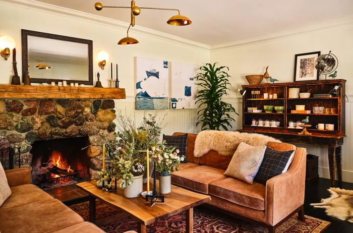 Brown sofas nestled beside a wood-burning stone fireplace