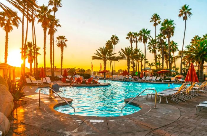 A scenic rocky beach adorned with palm trees and a few beachgoers in San Diego, California.