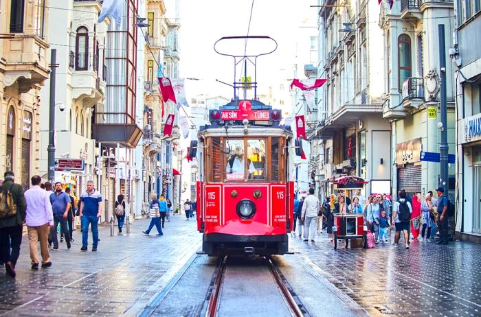 A striking view of a red trolley car navigating a street in Istanbul.