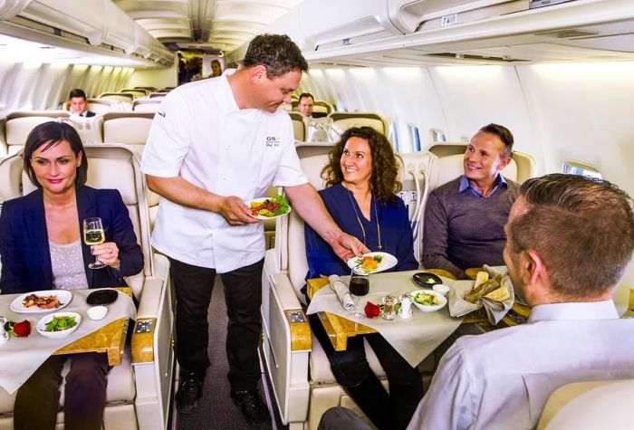 A chef catering to passengers aboard a Boeing 757 aircraft equipped with 50 business-class seats.