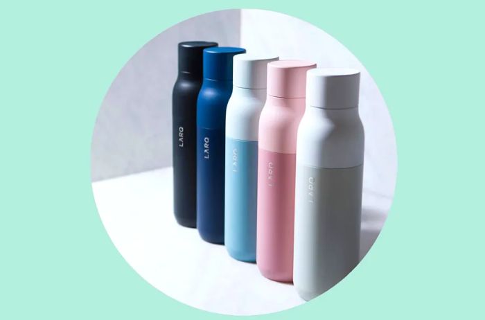 A collection of five Larq water bottles: black, blue, pale green, pale pink, and gray