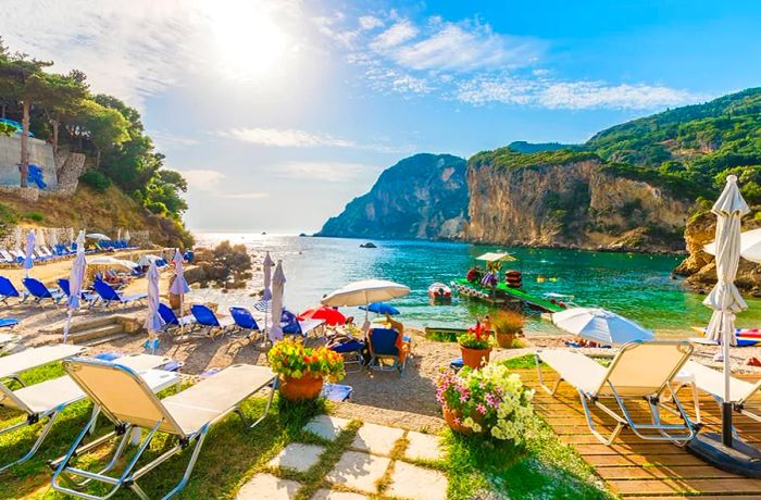 Sunbeds and umbrellas lining the beach on Corfu Island, Greece