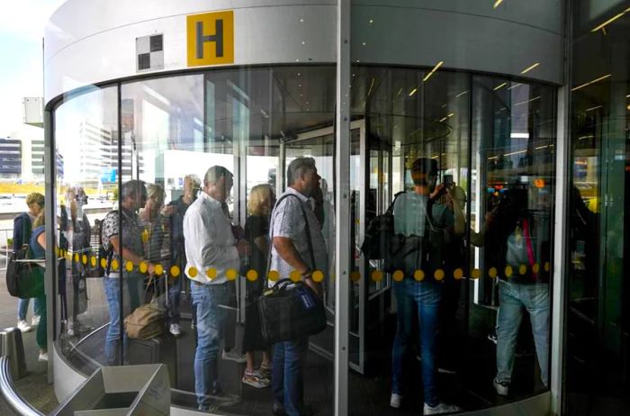 Yet travelers continue to arrive—long lines form for check-in at Amsterdam's Schiphol Airport.