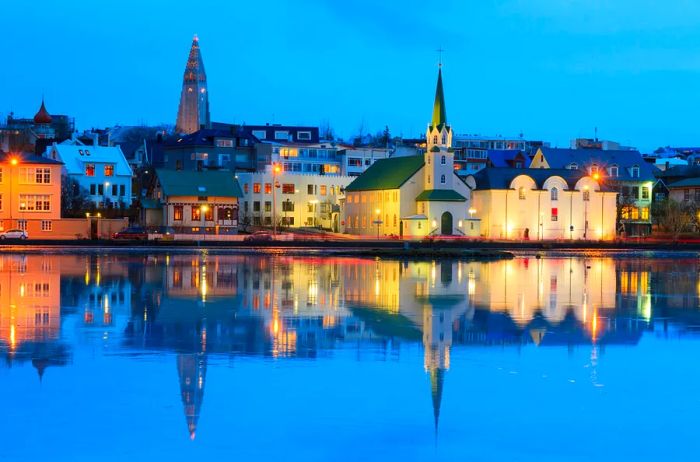 Twilight view of Reykjavík's low-rise skyline mirrored in Lake Tjörnin