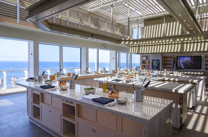 A spacious double U-shaped cooking area designed for cooking classes, featuring windows that overlook the ocean on Silversea's 