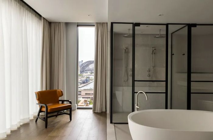 The Liberty Suite at Capella Sydney features a luxurious deep soaking tub and a spacious marble shower.