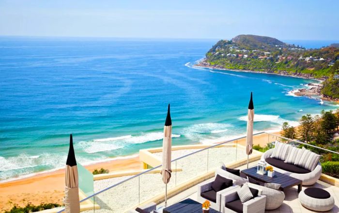 An outdoor terrace featuring navy and gray seating overlooks the beach.