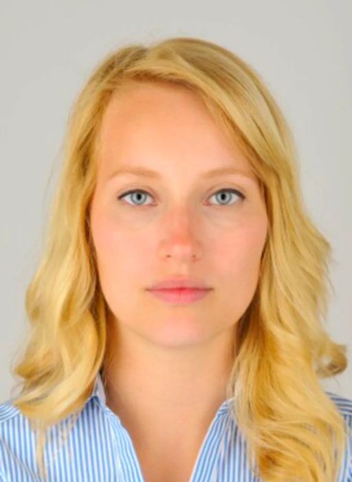 Example of a passport photo featuring a blonde woman wearing a white and blue collared shirt, set against an off-white background.