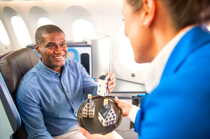 A flight attendant on KLM Business Class distributing the airline's collectible miniature Delft Blue houses.