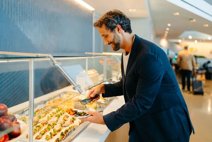 A man helping himself at the buffet in the United lounge at Newark airport