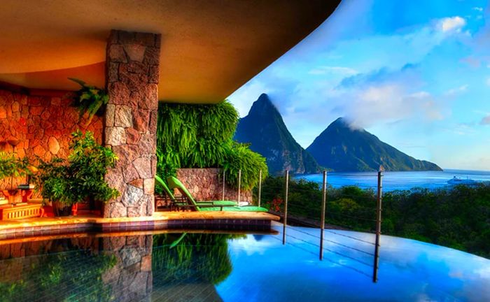 A glimpse of a serene hotel pool with a stunning view of St. Lucia's iconic pitons.