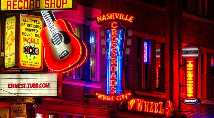 Neon signs illuminate Broadway Street at night in Nashville, Tennessee