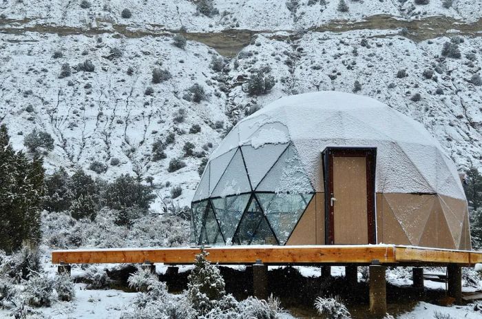 A Clear Sky Resorts dome blanketed in snow, surrounded by a winter wonderland.