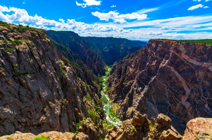 Two steep, dark brown cliffs with a river flowing between them