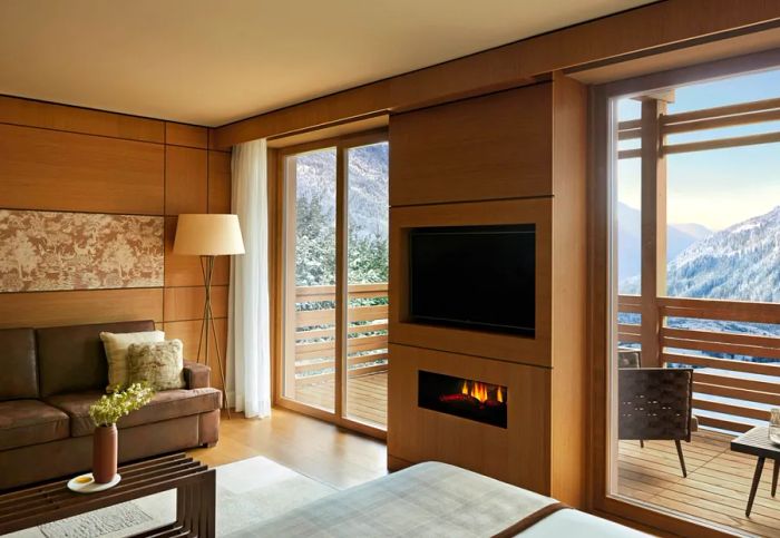 This Junior Suite at Lefay Resort & Spa Dolomiti boasts a spacious wooden terrace with stunning views of the Dolomite mountain range.