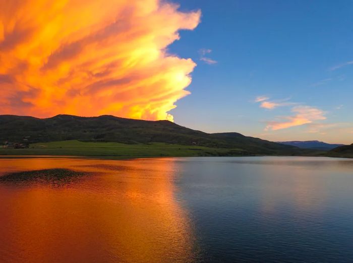 Sunset casting orange hues over a tranquil lake