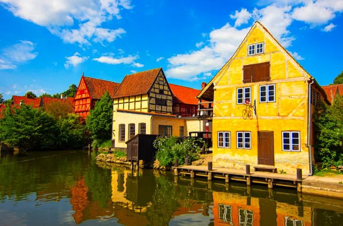 Half-timbered houses in shades of yellow, cream, and red at the open-air Den Gamle By museum in Aarhus.