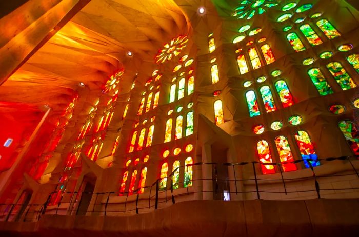 The vibrant stained-glass windows of the Sagrada Família church, illuminated by sunlight filtering through them