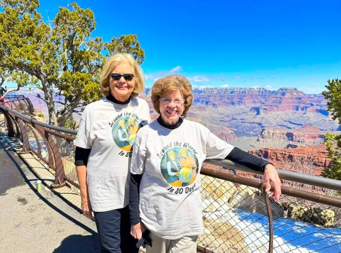 Ellie Hamby and Sandy Hazelip posing by a canyon overlook, proudly wearing their 