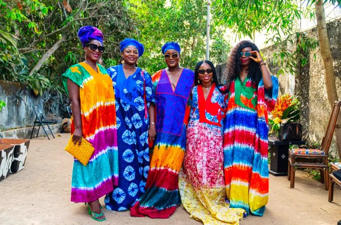 Five women showcasing vibrant Madam Wokie caftans outdoors