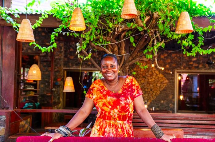 Fashion designer Maryann Kaikai dons a vibrant red and orange tie-dyed dress