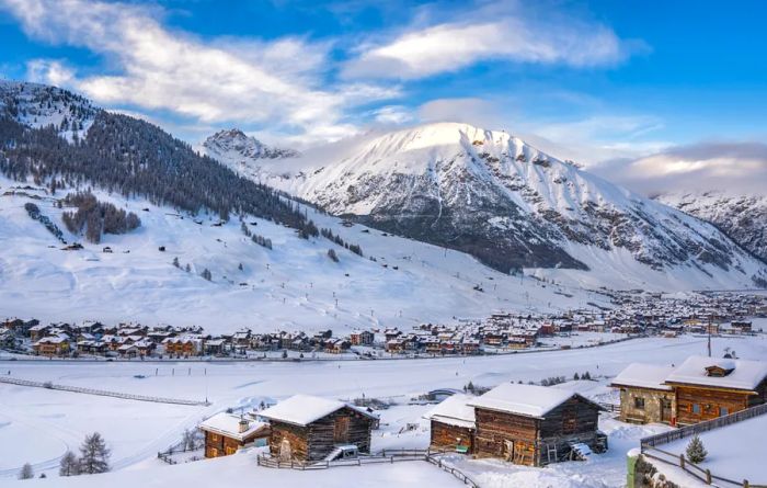 Charming, snow-covered wooden houses nestled among snow-capped mountains and evergreens