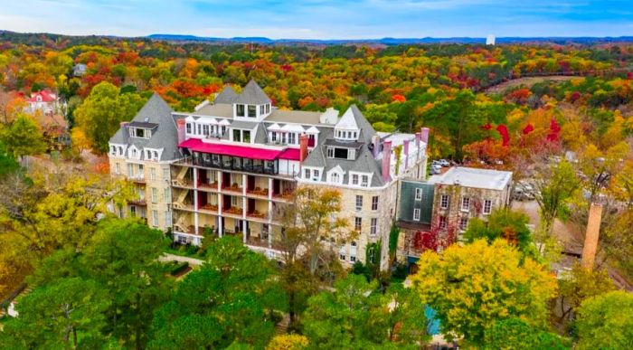 The 1886 Crescent Hotel & Spa in Eureka Springs, Arkansas, surrounded by vibrant deciduous trees during autumn.