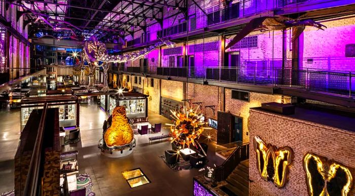 The JW Marriott Savannah Plant Riverside District's public areas feature exposed brick walls and modern sculptures, beautifully illuminated at night with purple lighting.