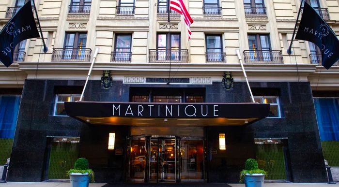 The entrance of Martinique New York on Broadway features a striking large black marquee.