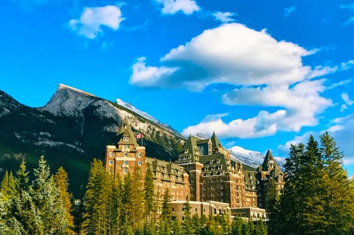 The impressive, historic Fairmont Banff Springs is set against a backdrop of towering evergreens and majestic mountains.