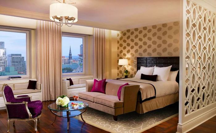 A guest room interior at the Ritz-Carlton Montreal features a sofa at the foot of the bed.