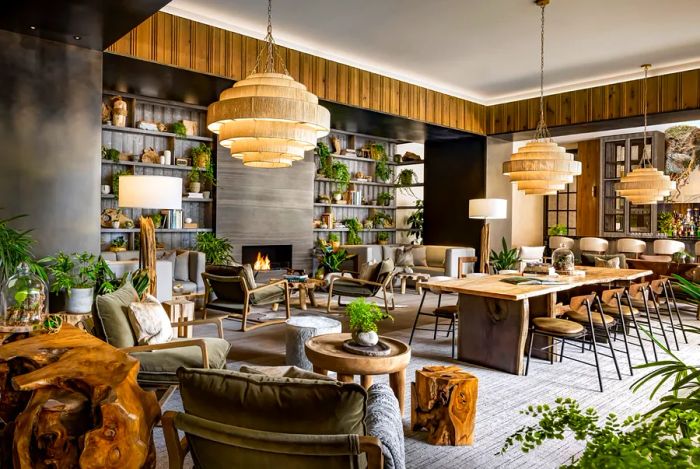 1 Hotel Toronto's lobby showcases green plants, a cozy fireplace, and wooden furniture.