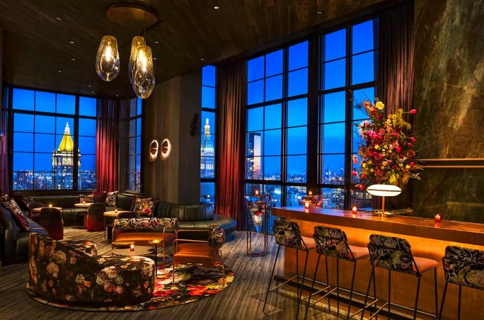 The Fleur Room at twilight, showcasing city views through its tall windows.