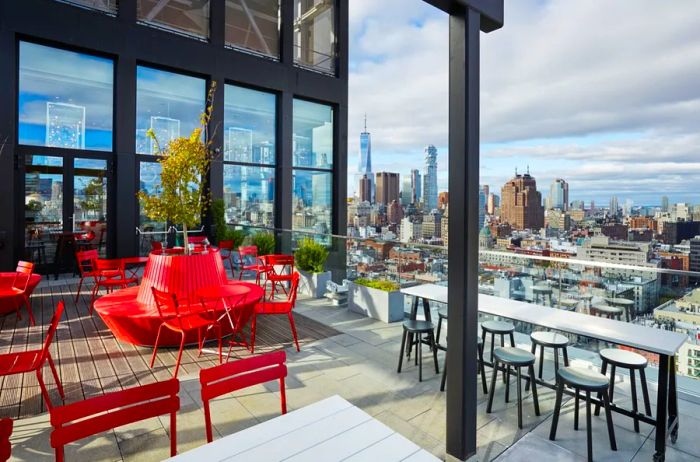 The rooftop bar at citizenM, showcasing red seating against a backdrop of skyline views.