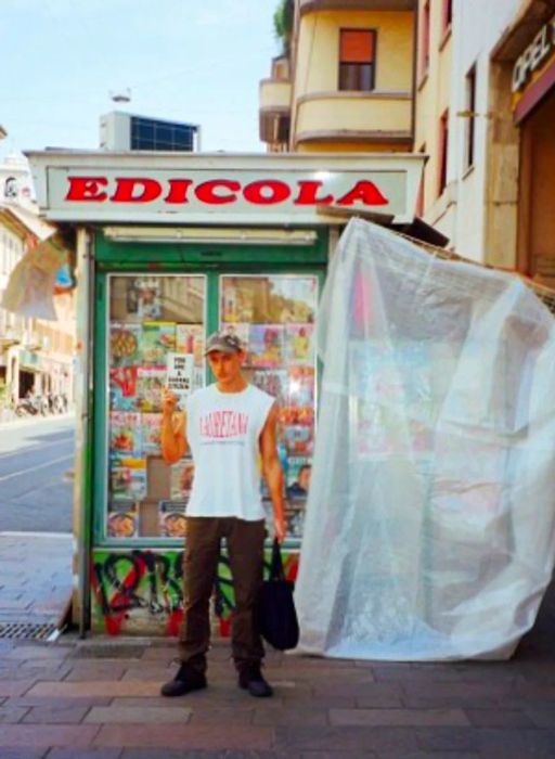 Damon Dominique poses with his book in front of a kiosk.