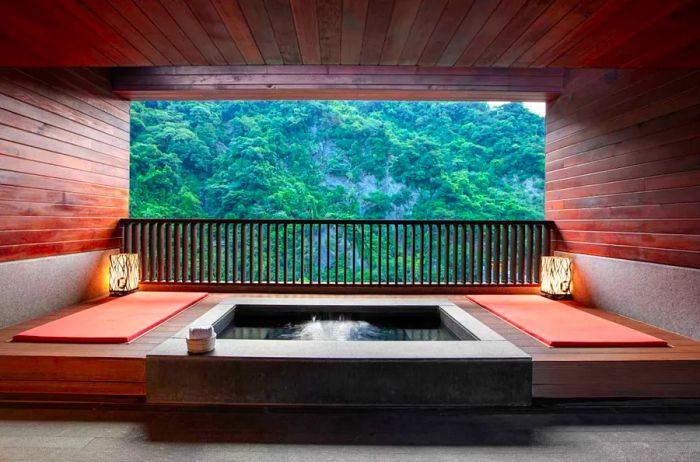 A Japanese-style tub with a view of a lush, tree-covered mountain at Pause Landis