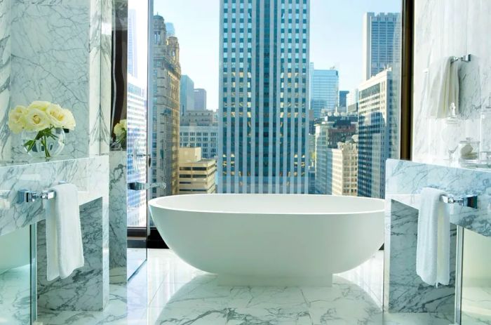 A luxurious soaking tub positioned by a window with views of downtown Chicago