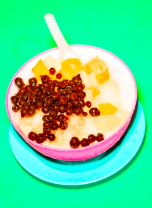 An enticing image of ice kachang adorned with fruits, jellies, and tapioca pearls.