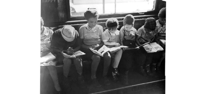 Children engrossed in reading at a window of the Quincy Branch Library, now known as the Langston Hughes Branch.