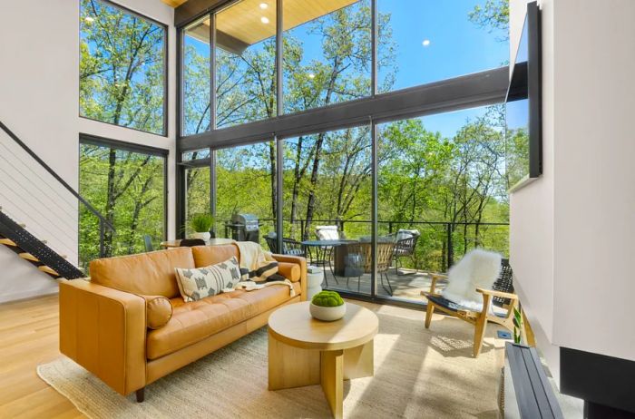 Contemporary tree house cabin featuring floor-to-ceiling windows for breathtaking views of the trees